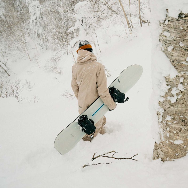 Freeride snowboarder standing with Cadet snowboard by United Shapes