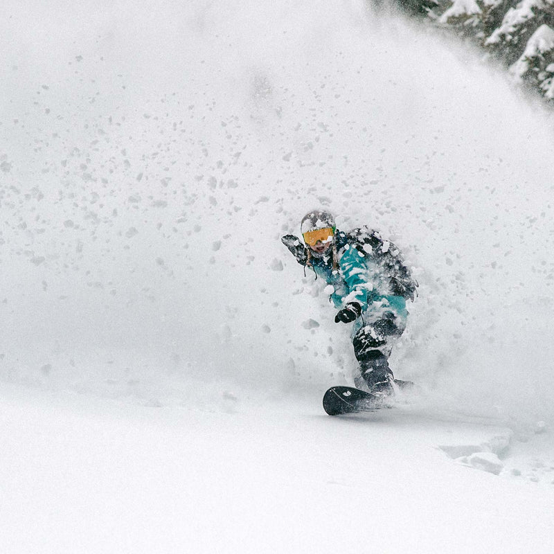 Snowboarder riding deep powder with splitboard Covert by United Shapes