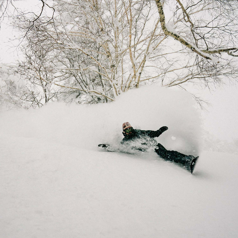 Snowboarder riding deep powder with Deep Reach United Shapes snowboard