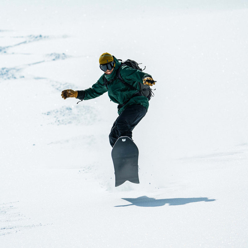 Happy snowboarder riding the Experiment snowboard by United Shapes