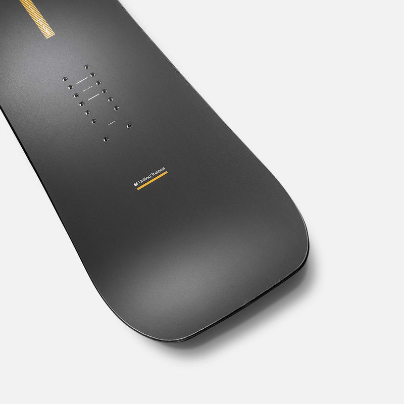 United Shapes black and yellow all-mountain snowboard Horizon tail close-up shot