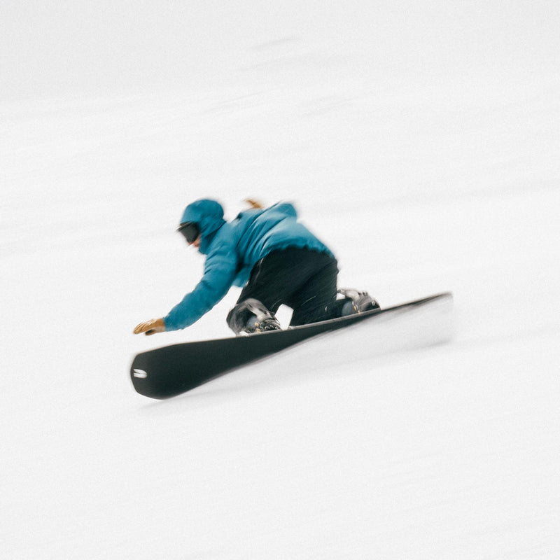 Snowboarder carving with the United Shapes Transmission board