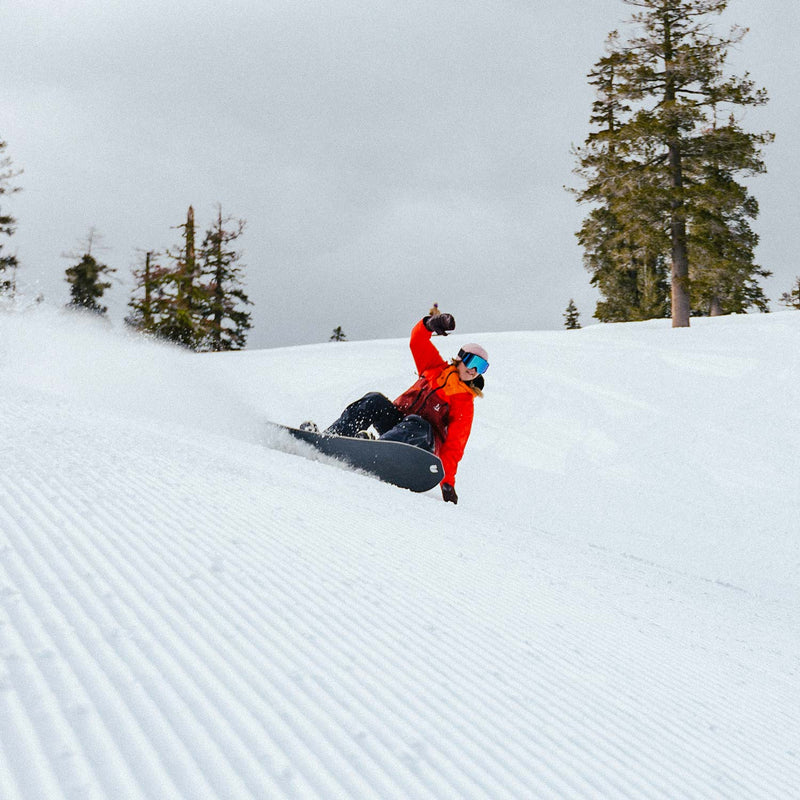 Girl snowboarder carving with the United Shapes Transmission board
